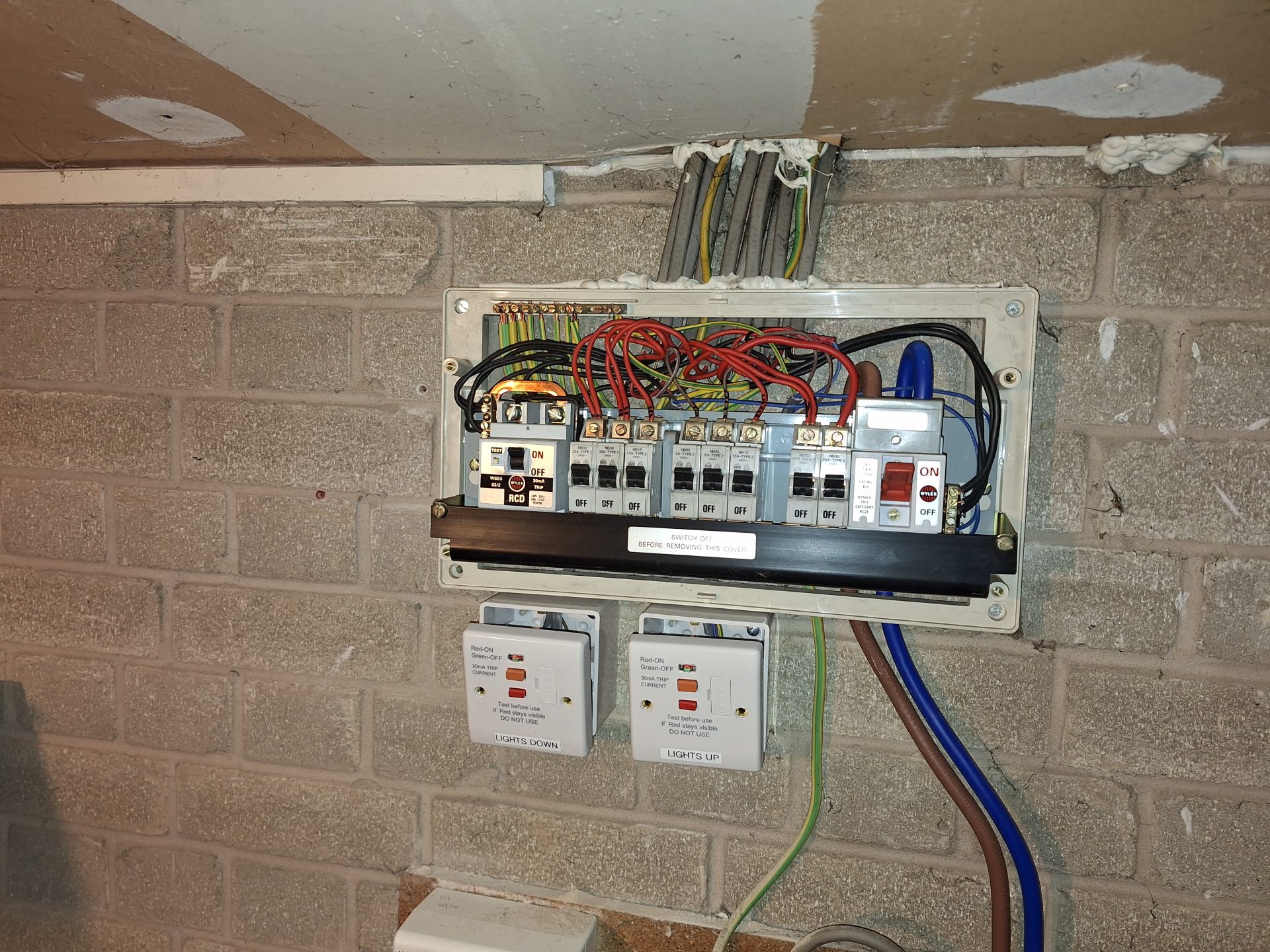 Old rewireable fuse board with exposed wiring before a consumer unit replacement