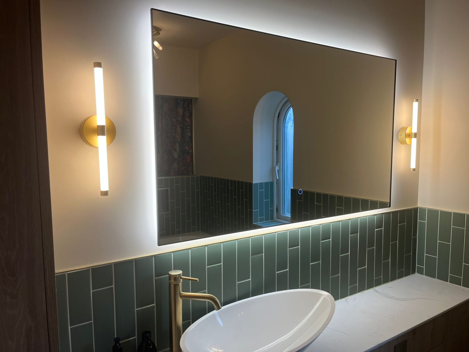 Backlit bathroom mirror and wall lights fitted by a kitchen and bathroom electrician in Nottingham