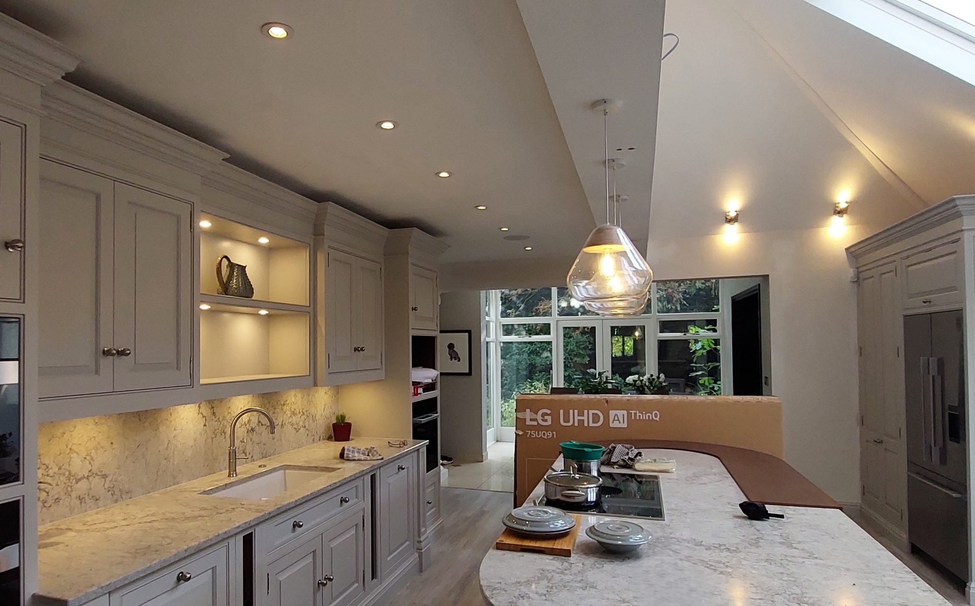 Kitchen with recessed downlights, under-cabinet lighting and a glass pendant over the island