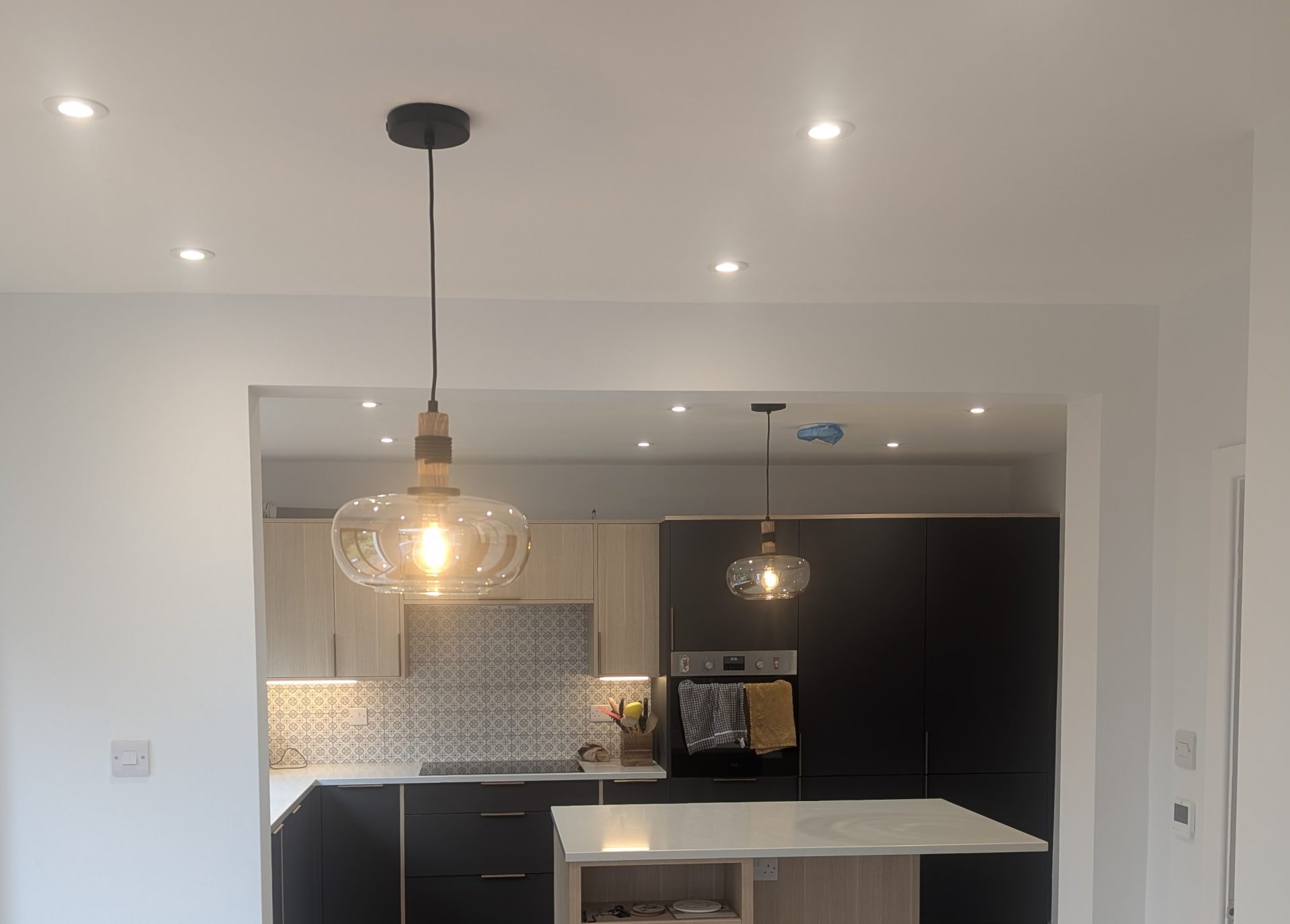 New kitchen in a house extension with pendant lights and recessed downlights