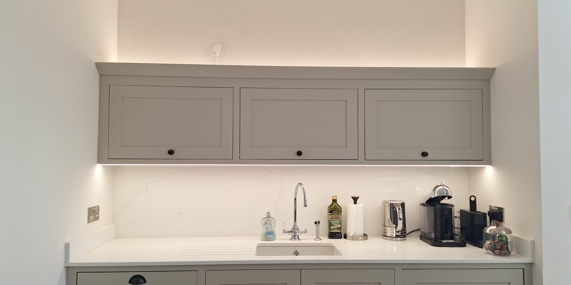 Kitchen units with under-cabinet LED strip lighting above the sink